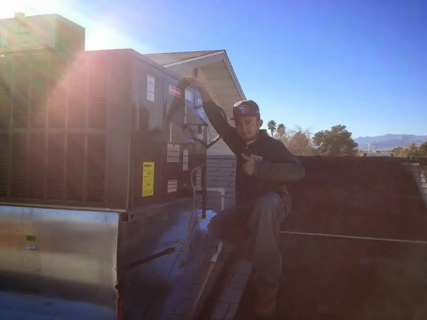 HVAC technician performing Boiler Repair on a rooftop unit in Fort Hood